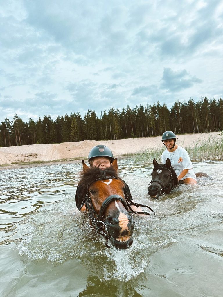 Ratsanikud ujuvad hobustega veekogus